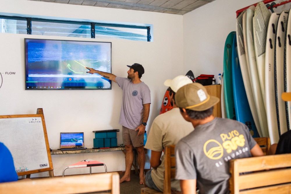Coach reviewing surf video with athletes